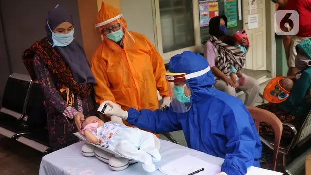 FOTO: Berikan Imunisasi, Bidan di Tangerang Kenakan APD Lengkap