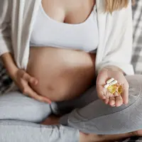 ibu hamil sedang meminum suplemen vitamin untuk sang buah hati. sumber foto: freepik