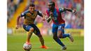 Bintang muda Arsenal, Oxlade Chamberlain berebut bola dengan pemain Crystal Palace, Pape Souare pada laga Liga Inggris di Stadion Selhurst Park, Inggris, Minggu (16/8/2015). Arsenal taklukan Palace 2-1. (Reuters/John Sibley)