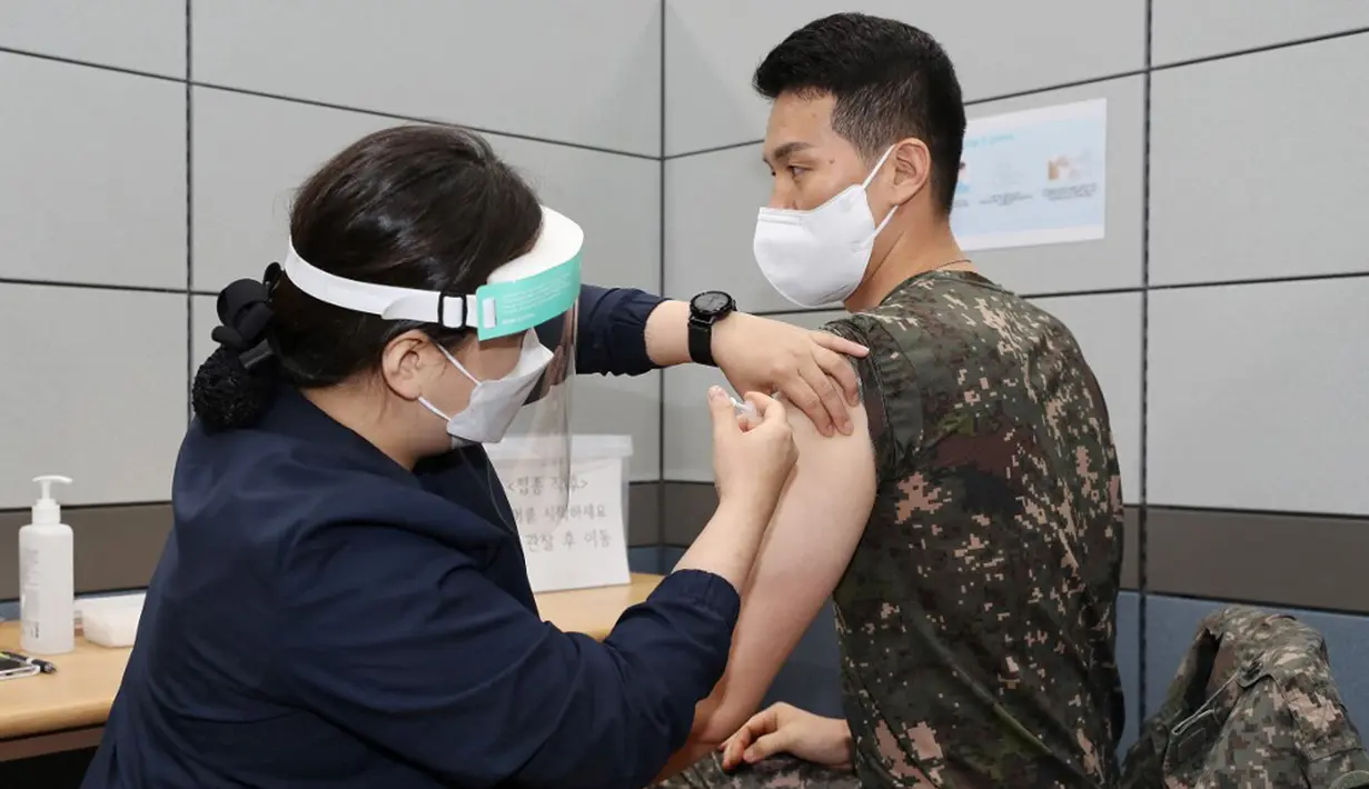 Seorang tentara Korea Selatan menerima dosis pertama vaksin virus corona COVID-19 AstraZeneca di Rumah Sakit Pusat Angkatan Bersenjata, Seongnam, selatan Seoul, Rabu (28/4/2021). Militer Korea Selatan mulai menjalani vaksinasi COVID-19. (Handout/South Korean Defence Ministry/AFP)
