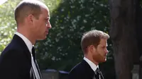 Pangeran William, Duke of Cambridge (kiri) dan Pangeran Harry, Duke of Sussex saat hadir di prosesi pemakaman Pangeran Philip, Duke of Edinburgh di Kapel St George di Kastil Windsor di Windsor, London, pada 17 April 2021. (ALASTAIR GRANT / AFP / POOL).