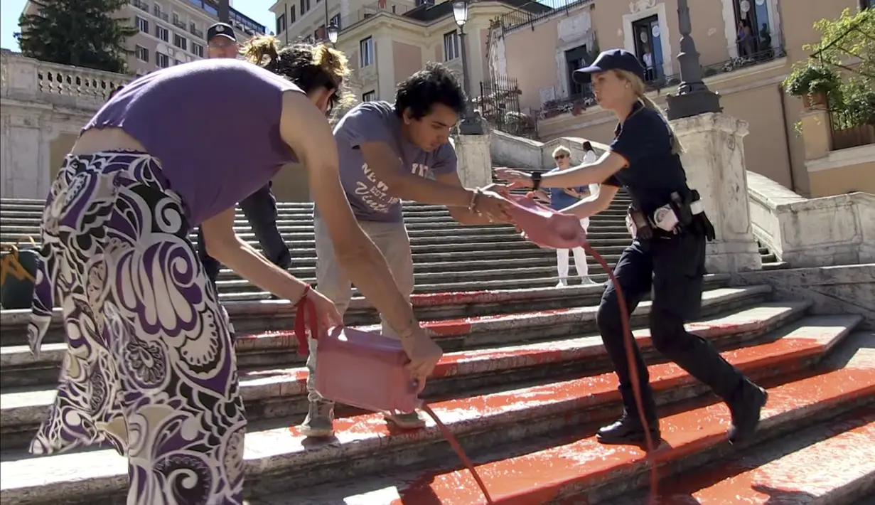 Para aktivis hak-hak perempuan memprotes feminisme dengan mengecat Spanish Steps yang terkenal di Roma dengan warna merah, yang secara simbolis melambangkan darah para perempuan korban kekerasan. (Lapresse via AP)