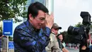 Dedi Prijono menutupi wajahnya saat dimintai keterangan awak media usai menjalani pemeriksaan di gedung KPK, Jakarta (1/8). Untuk kepentingan penyidikan, Dedi dicegah untuk berpergian ke luar negeri selama 6 bulan kedepan. (LIputan6.com/Helmi Afandi)