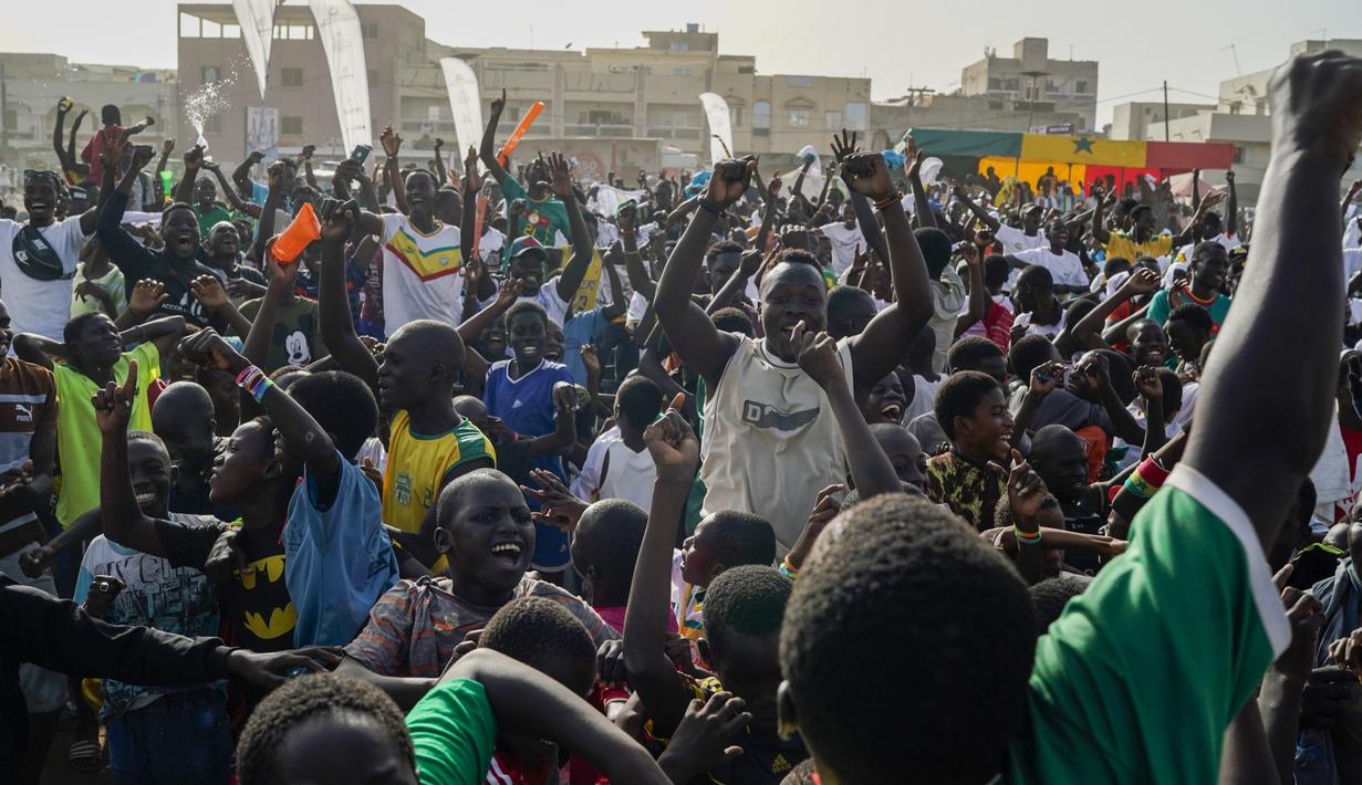 Penggemar klub sepak bola Senegal bereaksi terhadap skor tim mereka selama pertandingan sepak bola grup A Piala Dunia 2022 melawan Ekuador pada layar video yang dipasang di zona penggemar, Dakar, Senegal, Selasa (29/11/2022). Hasil ini dipastikan Senegal menyusul Belanda lolos ke babak 16 besar sebagai perwakilan grup A. (AP Photo/Leo Correa)