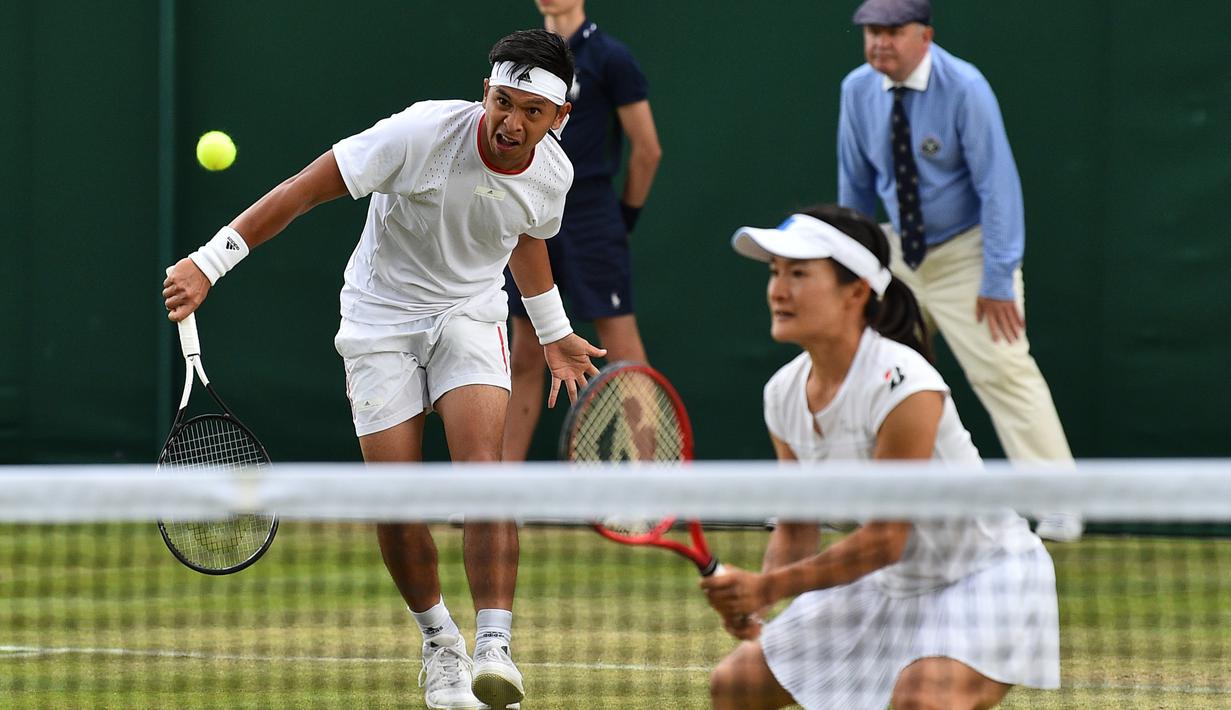 Petenis Indonesia Christopher Rungkat dan Shuko Aoyama dari Jepang mengembalikan bola ke petenis Kroasia Nikola Mektic dan Alicja Rosolska dari Polandia pada putaran kedua ganda campuran Wimbledon 2019 di All England Lawn Tennis Club, Senin (8/7/2019). Christo/Aoyama kalah 5-7, 4-6. (GLYN KIRK/AFP)
