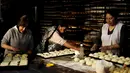 Para wanita saat membuat adonan roti untuk merayakan  peringatan All Saints di La Paz, Bolivia, Rabu (28/10/2015). Nantinya makanan - makanan ini akan dibawa ke pemakaman selanjutnya akan dilakukannya doa bersama. (REUTERS/David Mercadoâ)