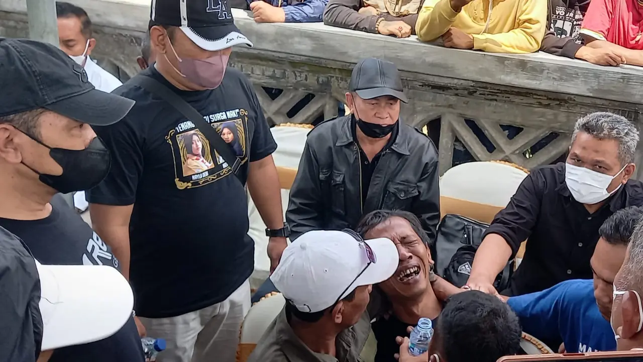 Devi Athok, ayah korban Kanjuruhan menangis saat datang di lokasi autopsi jenasah kedua anaknya di TPU Pathuk, Wajak, Malang, pada Sabtu, 5 November 2022. (Zainul/Liputan6.com)