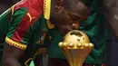 Gelandang Kamerun Christian Bassogog mencium piala saat merayakan kemenangan atas Mesir pada laga final Piala Afrika 2017 di Stade de I'Amitie, Gabon, Minggu (5/2). Kamerun juara Piala Afrika 2017 setelah menaklukkan Mesir dengan skor. (GABRIEL BOUYS/AFP)