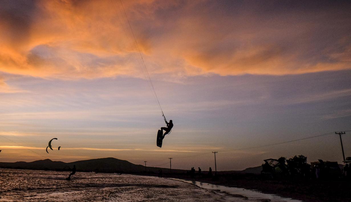 Menjelang malam peserta Kitesurfing tetap bersemangat melanjutkan aksinya pada ajang Third Kite Addict Kolombia tournamen di Cabo de la Vela, Guajira Departmen, Kolombia, (4/7/2016). (AFP/Joaquin Sarmiento)