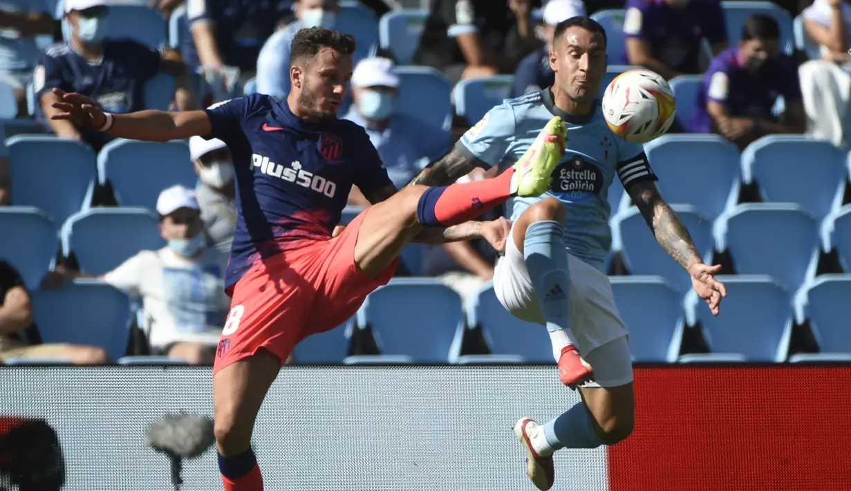 Gelandang Atletico Madrid, Saul Niguez (kiri) berebut bola dengan bek Celta Vigo, Hugo Mallo selama pertandingan La Liga Spanyol di stadion Balaidos di Vigo (15/8/2021). Atletico Madrid menang tipis atas Celta Vigo 2-1 berkat dua gol Correa. (AFP/Miguel Riopa)