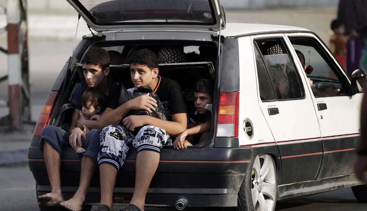 Menggunakan sebuah mobil, salah satu keluarga beserta anak-anak harus keluar dari Shujayeh, (20/7/2014), menyusul meningkatnya serangan militer Israel ke Gaza, Palestina. (REUTERS/Finbarr O'Reilly)