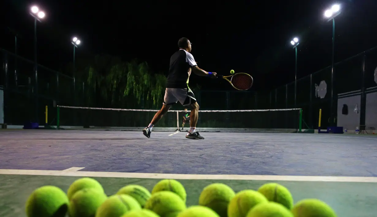 Orang-orang bermain tenis pada malam hari di lapangan tenis Taman Yuxiu, Yinchuan, Daerah Otonom Etnis Hui Ningxia, China, 3 Agustus 2020. Kota Yinchuan menyediakan berbagai fasilitas (venue) olahraga yang memadai bagi warganya untuk berolahraga di malam hari. (Xinhua/Jia Haocheng)