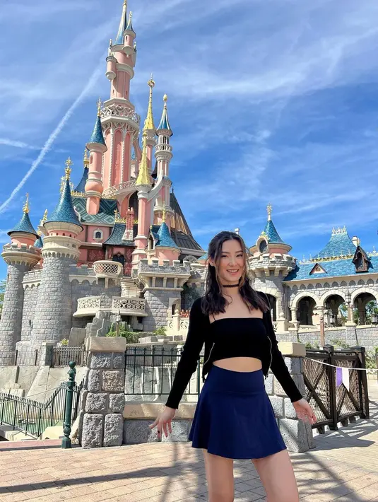 Saat mengunjungi Disneyland, ia tampil dengan rok mini dan strapless cropped top warna hitam. (Foto: Instagram @karbearv)