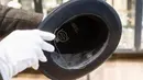 Pegawai memegang topi berinisial AH sebelum lelang memorabilia Nazi di Grasbrunn, Jerman, Rabu (20/11/2019). Menurut rumah lelang Hermann Historica dalam websitenya, topi Adolf Hitler tersebut terjual dengan harga 50 ribu euro atau sekitar Rp 781,7 juta. (Matthias Balk/dpa via AP)