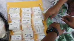 Dit Narkoba Polda Metro Jaya menata barang bukti hasil Operasi Bersinar Jaya 2016 di Jakarta, Rabu (13/4). Petugas mengungkap peredaran narkoba internasional dengan mengamankan 750 butir happy five senilai Rp202,608 miliar. (Liputan6.com/Gempur M Surya)