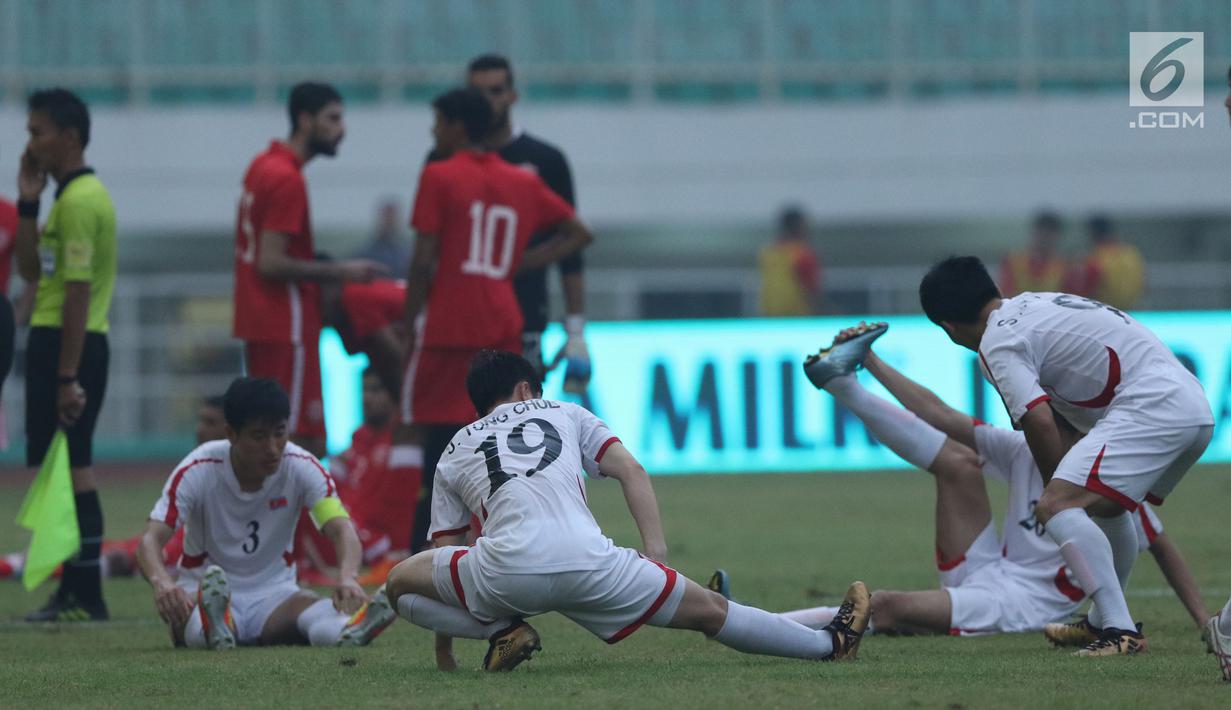 Pemain Korea Utara melakukan peregangan saat laga melawan Bahrain dihentikan sementara akibat lampu mati pada  PSSI Anniversary Cup 2018 di Stadion Pakansari, Kab Bogor, Kamis (3/5). Laga dimenangkan Bahrain 4-1. (Liputan6.com/Helmi Fithriansyah)