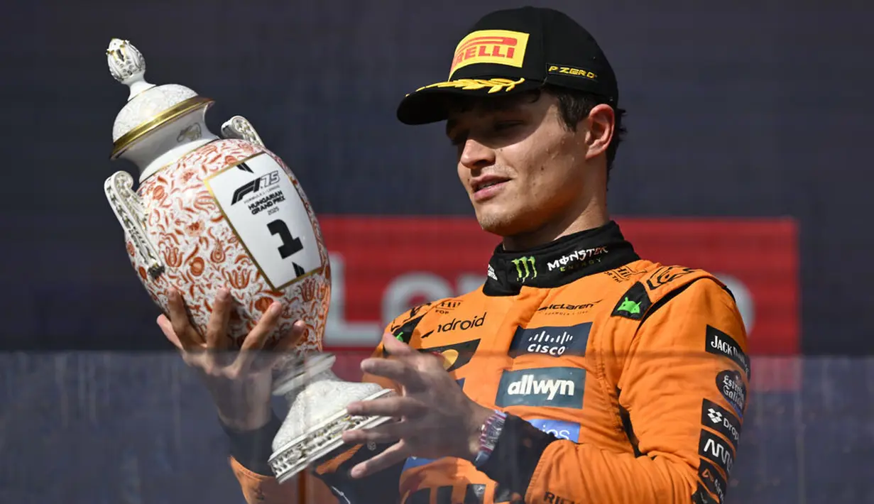 Pembalap McLaren, Lando Norris melihat trofi juara saat merayakan kemenangan dalam ajang balap Formula 1 GP Hungaria 2025 di sirkuit Hongaroring, Minggu (03/08/2025) waktu setempat. (AP Photo/Denes Erdos)
