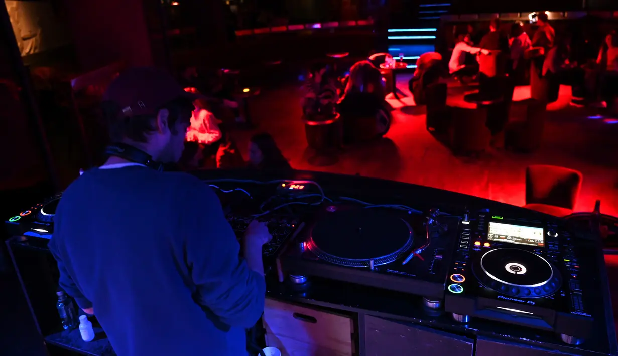 Seorang DJ tampil di Kafe Berlin di Madrid (17/1/2021). Di Madrid, pemerintah daerah mencabut jam malam dari tengah malam hingga jam 11 malam dengan restoran dan bar tutup satu jam sebelumnya dalam sebuah langkah yang berlaku pada 18 Januari 2021. (AFP/Gabriel Bouys)