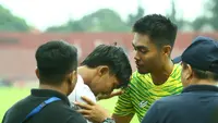Kurniawan Kartika Ajie memberi semangat Yusuf Meilana yang merasakan sakit di lututnya. (Bola.com/Gatot Sumitro)