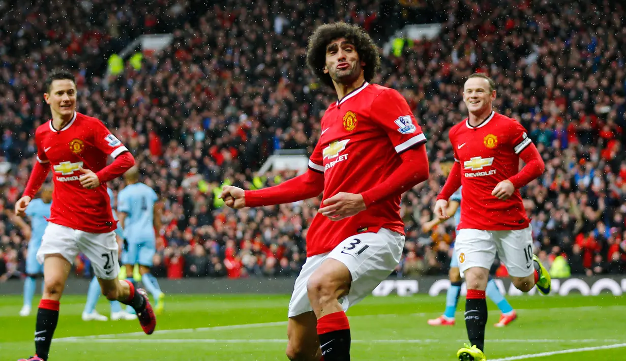 Gelandang Manchester United, Marouane Fellaini (tengah) merayakan selebrasi usai mencetak gol ke gawang Manchester City saat Laga Liga Premier Inggris di Old Trafford, Minggu (12/4/2015). Manchester United menang 4-2 atas City. (Reuters/Darren Staples)