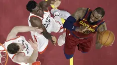 Aksi pemain Cleveland Cavaliers, LeBron James  mencoba melewati adangan dua pemain Toronto Raptors pada lanjutan NBA basketball game di Quicken Loans Arena, (21/3/2018) Cleveland. Cavs menang 132-129. (AP/Tony Dejak)