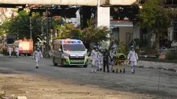 Pakar penyelamat Kamboja dan Thailand berjalan melalui reruntuhan bangunan di lokasi kebakaran besar kasino hotel Kamboja di Poipet, Kamboja, Jumat (30/12/2022). Dalam laporan sementara polisi Kamboja, ada 30 orang terluka akibat kebakaran itu. (AP Photo/Heng Sinith)