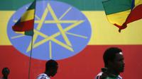 Warga melintas di depan replika raksasa bendera Ethiopia (AFP/Jose Cendon)