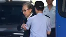 Mantan presiden Korea Selatan Lee Myung-bak diperiksa petugas di pengadilan saat menghadiri persidangan di Seoul (6/9). Pria 76 tahun itu dituduh menggelapkan puluhan juta dolar AS dari DAS, produsen suku cadang otomotif lokal. (AFP Photo/Jung Yeon-je)
