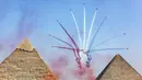 Pesawat K-8E Karakorum dari tim aerobatic "Silver Stars" Angkatan Udara Mesir tampil selama Pyramids Air Show 2022 di atas (kanan ke kiri) Great Pyramid of Khufu, Pyramid of Khafre, dan Pyramid of Menkaure di Giza Pyramids Necropolis, Mesir, 3 Agustus 2022. (Mahmoud Khaled/AFP)