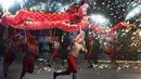 Penari melakukan tarian naga di sebuah taman pada hari keempat Tahun Baru Imlek di Beijing (8/2). China menandai kedatangan Tahun Babi dengan liburan Festival Musim Semi selama seminggu.  (AFP Photo/Greg Baker)