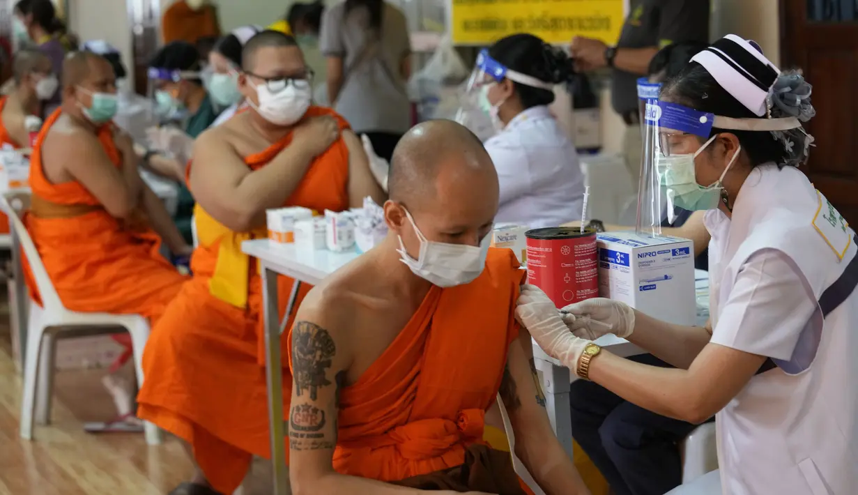 Petugas kesehatan menyuntikan vaksin kepada biksu Buddha di Wat Srisudaram di Bangkok, Thailand (30/7/2021). Para biksu tersebut mendapatkan dosis vaksin AstraZeneca COVID-19. (AP Photo/Sakchai Lalit)