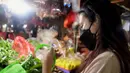 Momen tersebut dibagikan di kanal Youtube-nya Indah Permatasari. Mengenakan pakaian sederhana, dan masker menutup hidungnya, perempuan seorang anak itu tampak santai berjalan di pasar tradisional. [Youtube/Indah Permatasari]
