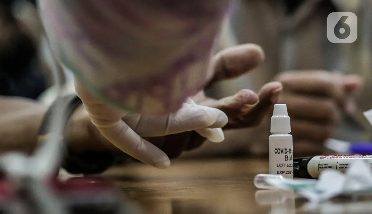 Petugas medis mengambil sampel wartawan yang bertugas di DPR saat rapid test di Ruang Wartawan, Kompleks Parlemen, Senayan, Jakarta, Rabu (1/7/2020). Rapid test yang digelar secara gratis ini untuk mendeteksi penyebaran dan memutus mata rantai Penyebaran Covid 19. (Liputan6.com/Johan Tallo)