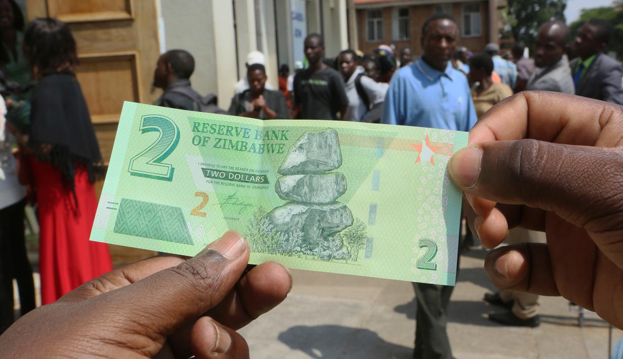 Seorang pria memegang salah satu uang kertas baru yang dikeluarkan Reserve Bank of Zimbabwe di Harare, 12 November 2019. Pemerintah Zimbabwe memperkenalkan kembali mata uang negaranya setelah hampir satu dekade terakhir menggunakan mata uang negara lain untuk bertransaksi. (AP/Tsvangirayi Mukwazhi)