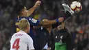 Striker Barcelona, Luis Suarez, berebut bola dengan bek Sevilla Simon Kjaer, pada laga La Liga Spanyol di Stadion Camp Nou, Barcelona, Sabtu (20/10). Barcelona menang 4-2 atas Sevilla. (AFP/Lluis Gene)