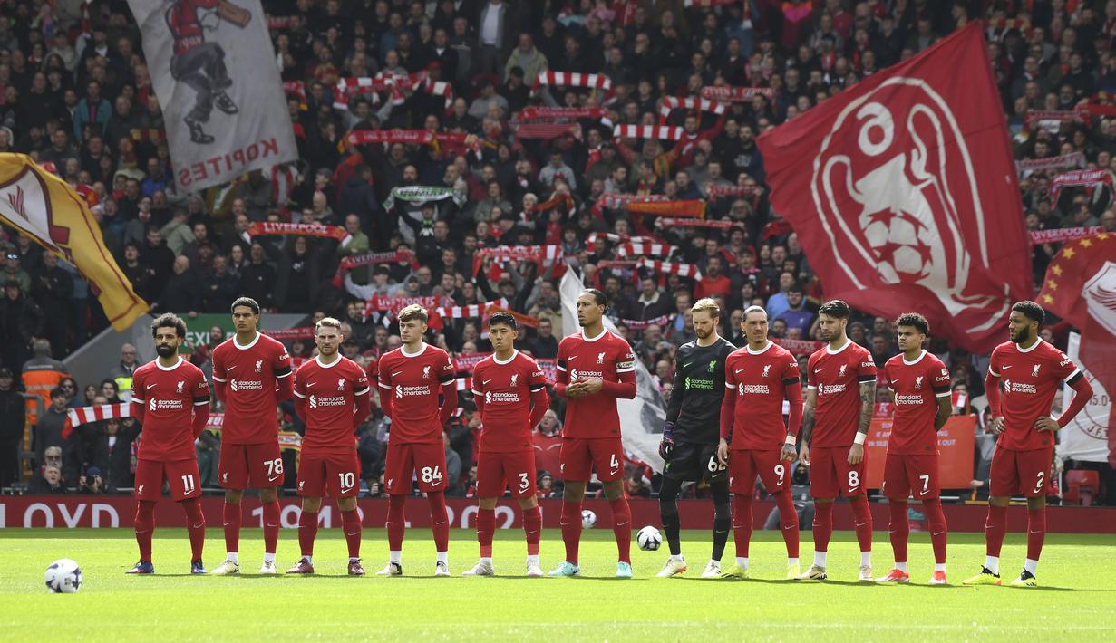 Para pemain starting XI Liverpool berbaris untuk mengheningkan cipta atas wafatnya eks pemain Liverpool, Larry Lloyd, sebelum dimulainya laga pekan ke-30 Premier League 2023/2024 menghadapi Brighton and Hove Albion di Anfield Stadium, Liverpool, Minggu (31/3/2024). (AP Photo/Rui Viera)