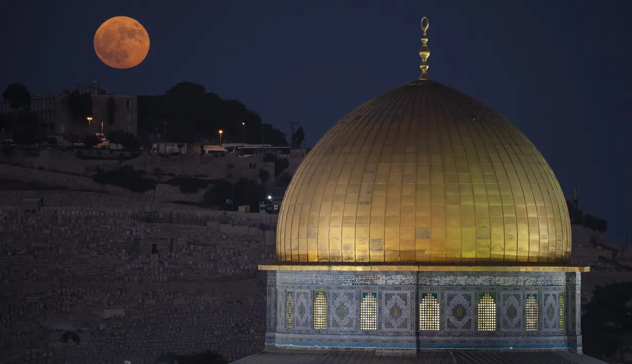 Bulan purnama terbesar atau supermoon terbit di balik kuil Dome of the Rock di kompleks Masjid Al Aqsa di Kota Tua Yerusalem, Senin, 19 Agustus 2024. (AP Photo/Leo Correa)