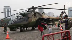 Warga berfoto berlatar helikopter TNI pada pameran Alat Utama Sistem Persenjataan TNI di Kawasan Monas, Jakarta, Kamis (27/9). Pameran ini bagian perayaan HUT TNI ke-73. (Liputan6.com/Helmi Fithriansyah)