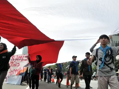 Komunitas Mahasiswa Pecinta Alam (Mapala) se-Jabodetabeka membentangkan bendera Merah Putih raksasa saat memperingati Hari Bumi di CFD Bundaran HI, Jakarta, Minggu (21/4). Aksi ini untuk memperingati Hari Bumi yang jatuh pada 22 April. (merdeka.com/Iqbal Nugroho)