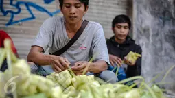 Seorang pedagang saat menata kulit ketupat dagangannya di sebuah pasar kawasan Ciracas, Jakarta, Kamis (16/7/2015). Menjelang Lebaran, warga mulai ramai membeli kulit ketupat. (Liputan6.com/Faizal Fanani)