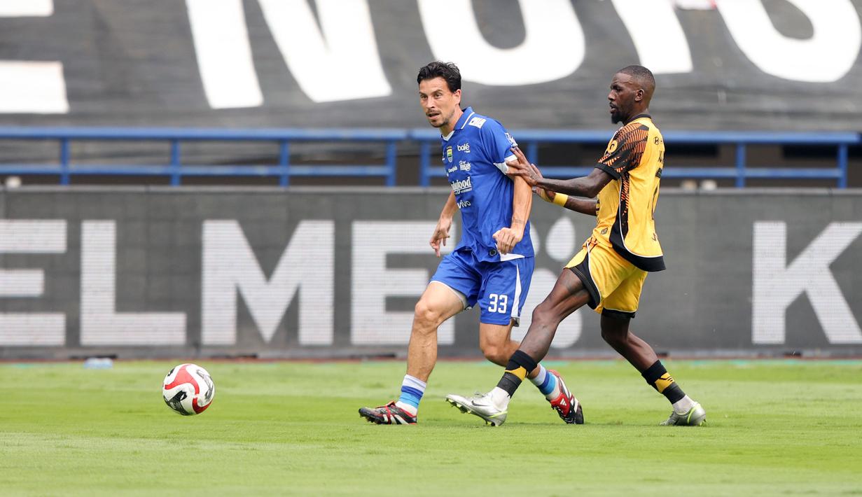 Pemain Persib Bandung, Thom Haye (kiri) berusaha melepaskan umpan dibayangi pemain Persija Jakarta, Allano De Souza Lima dalam laga lanjutan BRI Super League 2025/2026 di Stadion Gelora Bandung Lautan Api, Bandung, Minggu (11/01/2026). (Bola.com/Abdul Aziz)