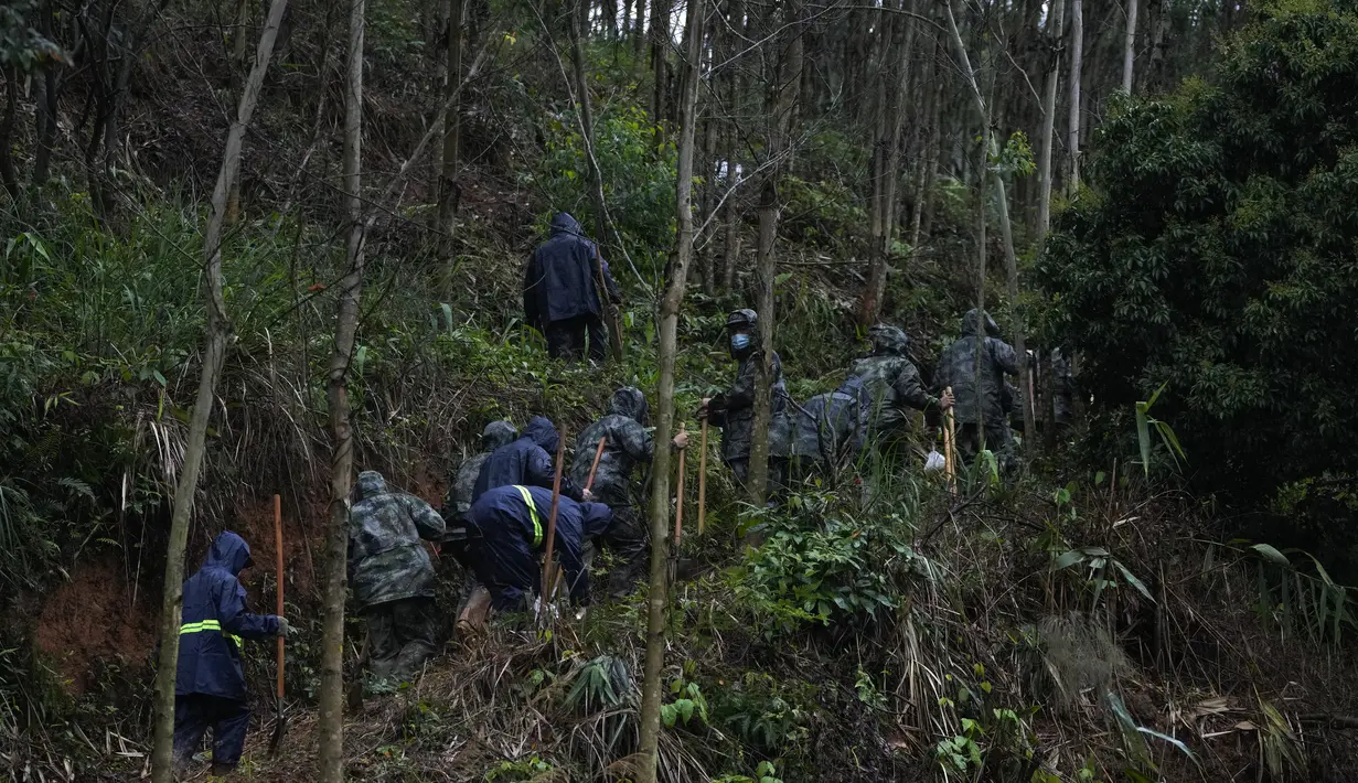 Tentara membawa sekop menuju lokasi jatuhnya pesawat Boeing 737-800 milik China Eastern Airlines  untuk mencari kotak hitam kedua di desa Molang, di provinsi Guangxi, China barat daya, Rabu (24/3/2022). (AP Photo/Ng Han Guan)