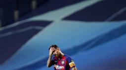 Striker Barcelona, Lionel Messi, memegang kepalanya usai ditaklukkan Bayern Munchen pada laga perempat final Liga Champions di Estadio da Luz, Sabtu (15/8/2020). Barcelona takluk 2-8 dari Bayern Munchen. (AP/Manu Fernandez/Pool)