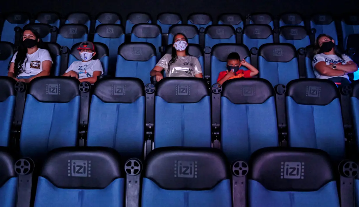Orang-orang menikmati film di bioskop yang dibuka kembali menyusul pelonggaran langkah-langkah yang diberlakukan oleh pemerintah Kolombia untuk menghentikan penyebaran Covid-19, di Cali, Kolombia pada Jumat (2/10/2020). (Photo by Luis ROBAYO / AFP)