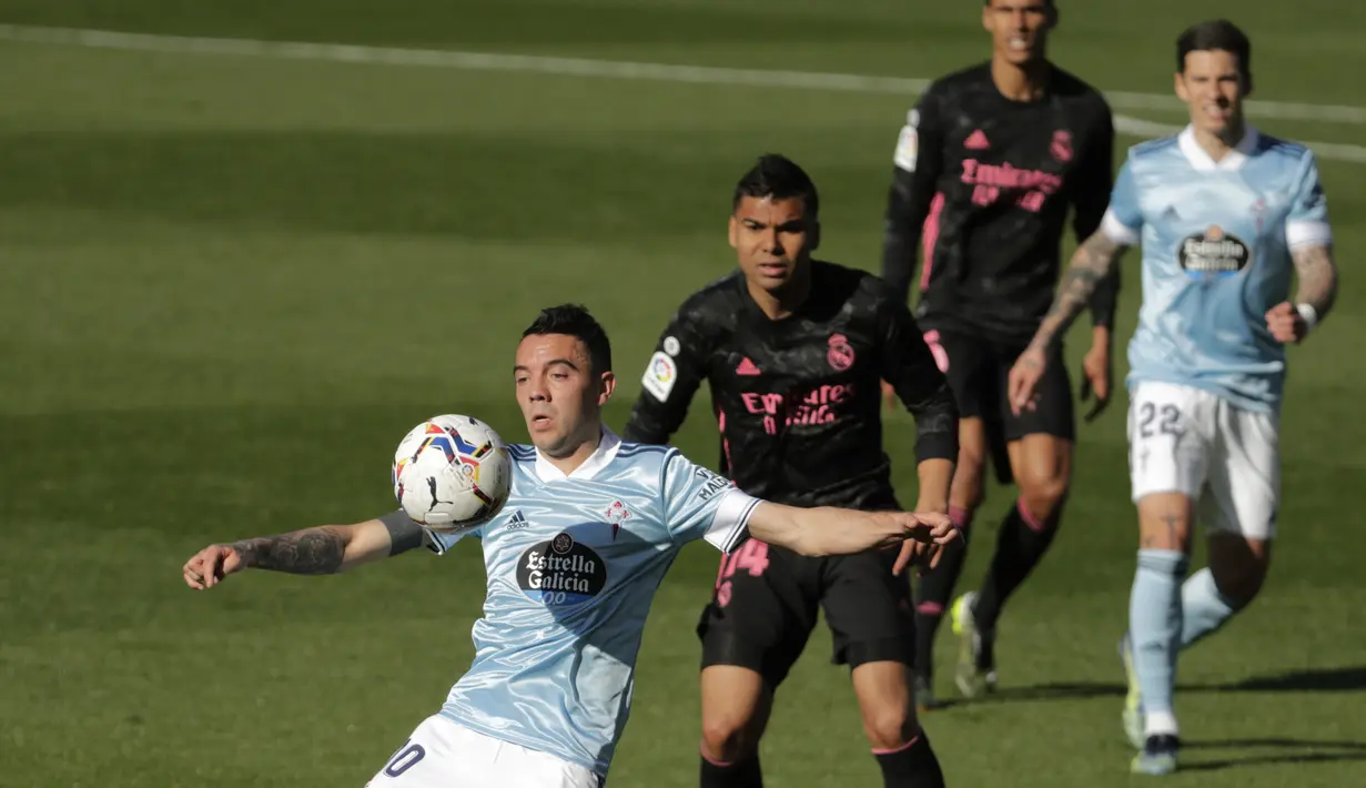 Penyerang Celta Vigo, Iago Aspas mengontrol bola di depan gelandang Real Madrid, Casemiro pada lanjutan Liga Spanyol 2020/2021 di Balaidos, Sabtu (20/3/2021). Karim Benzema jadi bintang saat Real Madrid melibas Celta Vigo 3-1. (AP Photo/Lalo R.Villar)