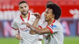 Pemain Sevilla, Jules Kounde, melakukan selebrasi usai mencetak gol ke gawang Barcelona pada laga leg pertama semifinal Copa del Rey di Estadio Ramon Sanchez Pizjuan, Kamis (11/2/2021). Barcelona tumbang dengan skor 2-0. (AP/Angel Fernandez)