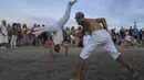 Penari Capoeira melakukan ritual untuk dewi laut Afrika Yemanja di Pantai Ramirez di Montevideo, Uruguay, Rabu (2/2/2022). Para pemuja mendatangi pantai pada pada hari raya Yemanja, membawa lilin, bunga, madu dan buah untuk menghormati dewi laut. (AP Photo/Matilde Campodonico)