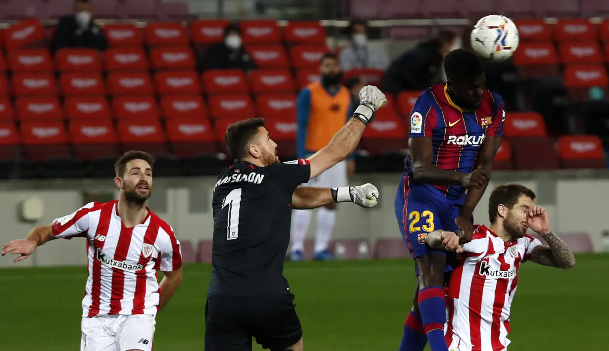 Bek Barcelona, Samuel Umtiti (kedua kanan) menyundul bola melewati kiper dan pemain Athletic Bilbao, Unai Simon dan Inigo Martinez pada pekan ke-21 Liga Spanyol 2020/21 di Stadion Camp Nou, Senin (1/2/2021) dini hari WIB. Barcelona sukses mengalahkan Athletic Bilbao 2-1. (AP Photo/Joan Monfort)