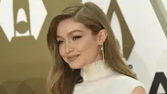 Gigi Hadid tersenyum saat tiba menghadiri CMA Awards tahunan ke-53 di Bridgestone Arena di Nashville, Tennessee (13/11/2019). Model berusia 24 tahun ini tampil memukau dalam balutan gaun putih. (AP Photo/Evan Agostini)
