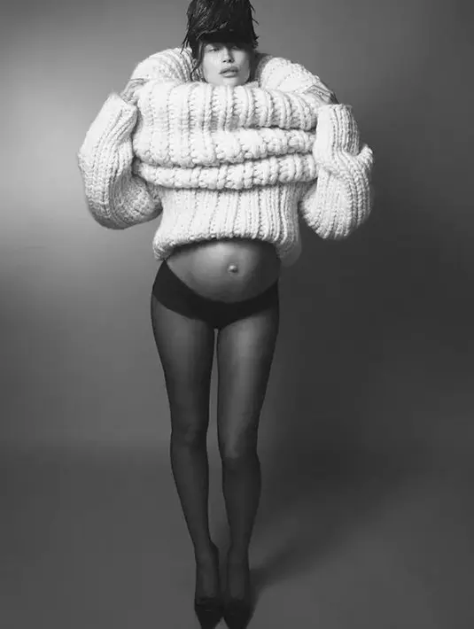 Lagi, gaya yang unik dan tak biasa, Hailey Bieber pamer baby bumpnya. Ia mengenakan sweater beraksen dramatis, sehingga tetap memperlihatkan baby bumpnya, dipadu dengan celana dalam hitam, topi bulu, dan high heels. [Foto: Instagram/jdblegend_]
